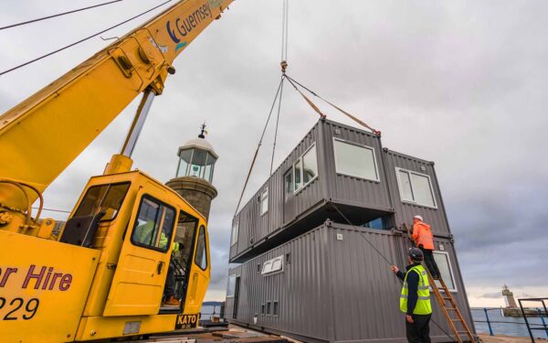 guernsey-horbours-crane lowered 40ft grey converted shipping container into position