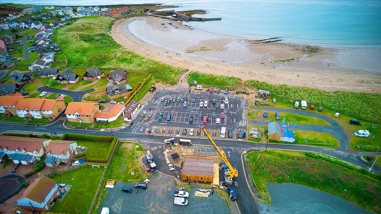 shipping container restaurant crane installation beadnell bay beach complete