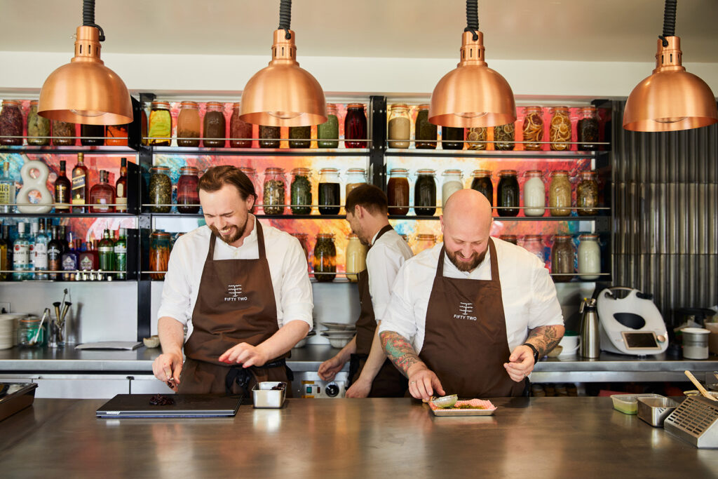 restaurant counter chefs smiling preparing food
