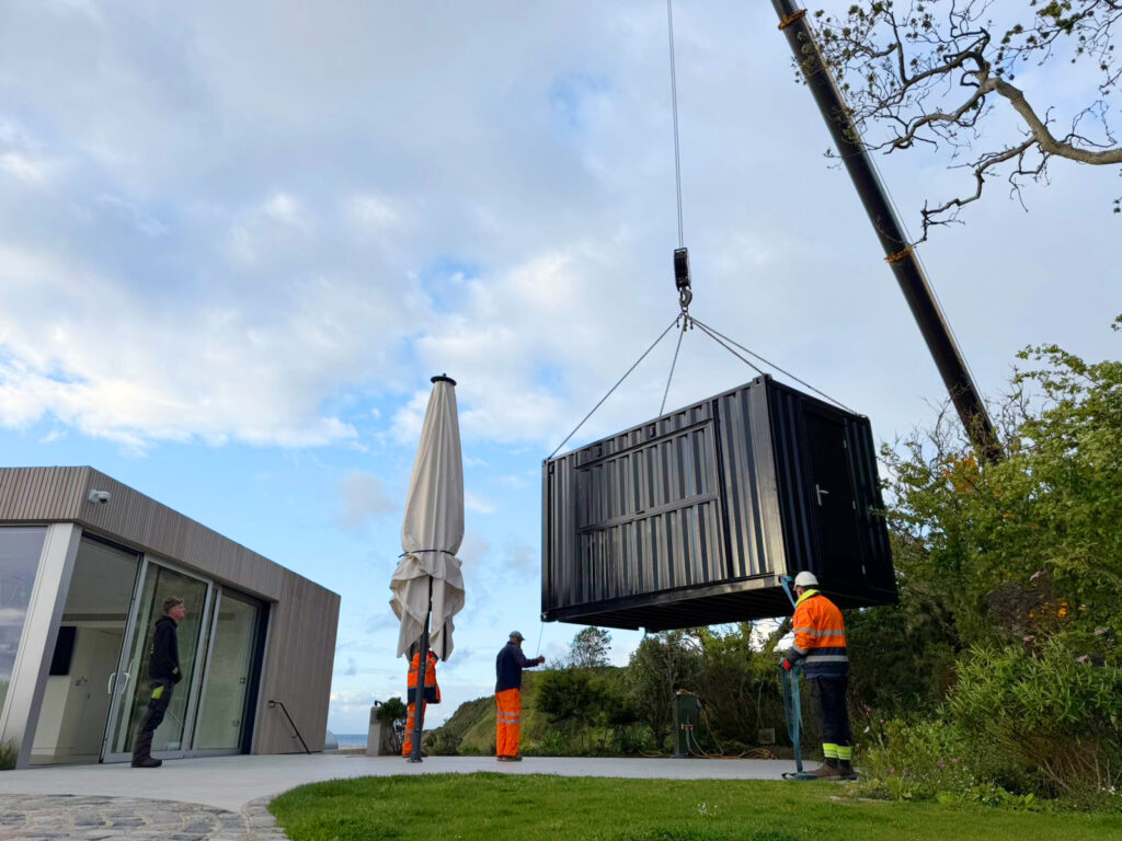 Crane lifting hotel container bar into site