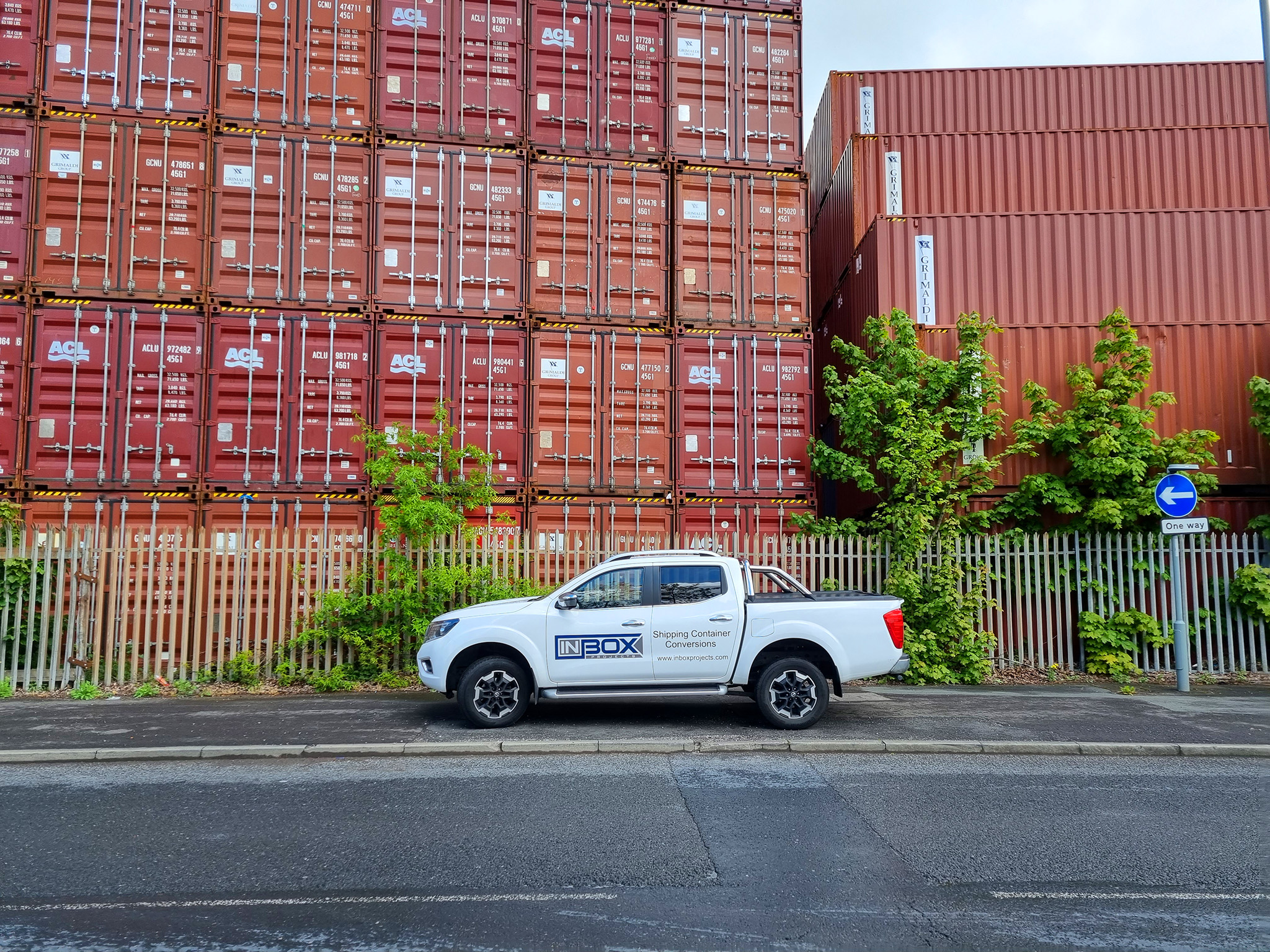 Large shipping container stack brown painted white toyota pickup truck inbox projects livery